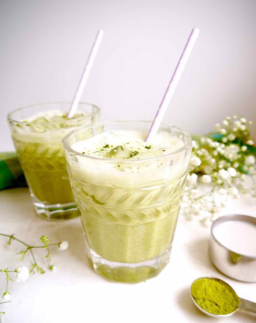 An almond milk matcha latte in two cups.