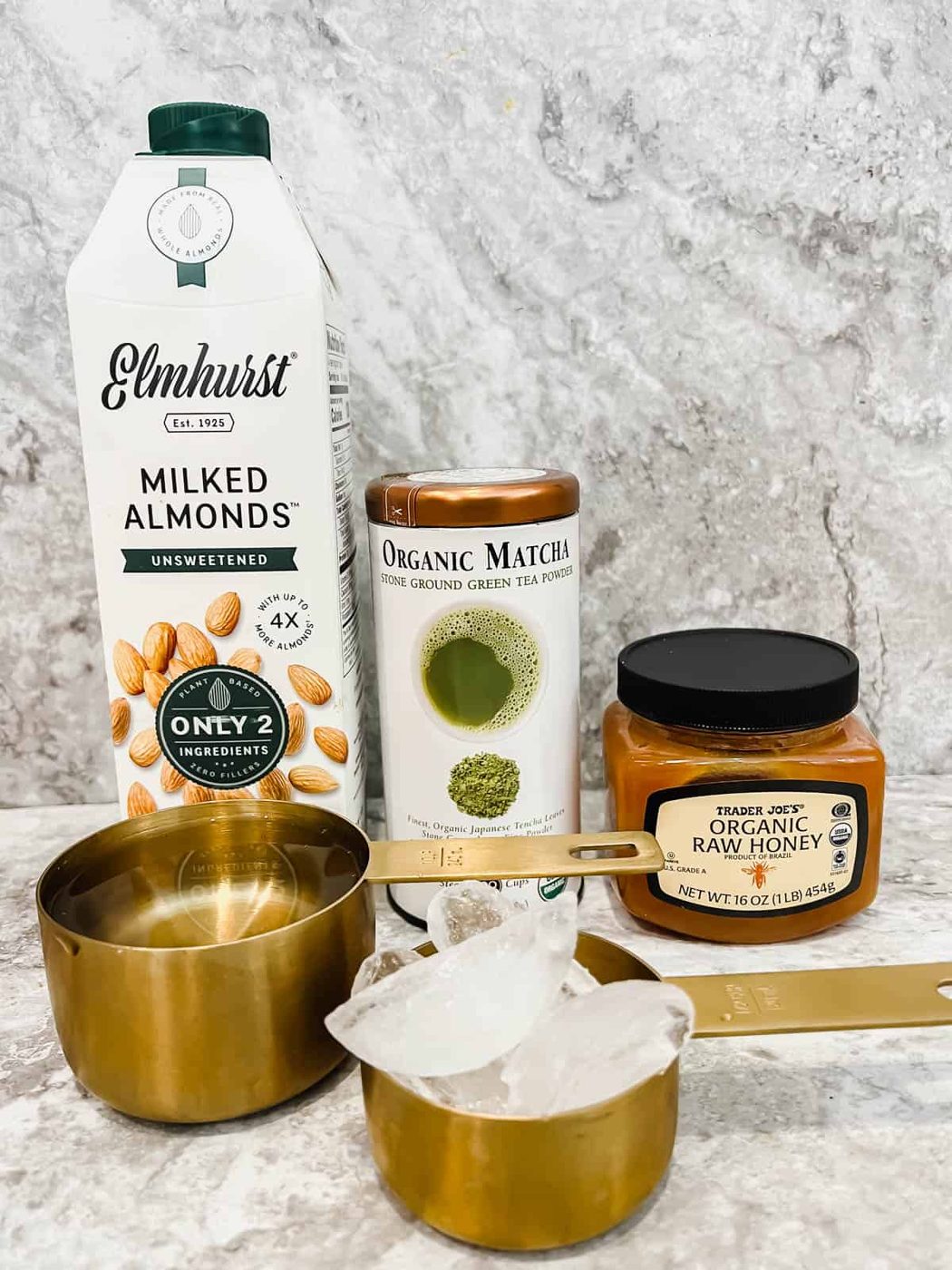 Ingredients needed to make an iced almond milk matcha latte.