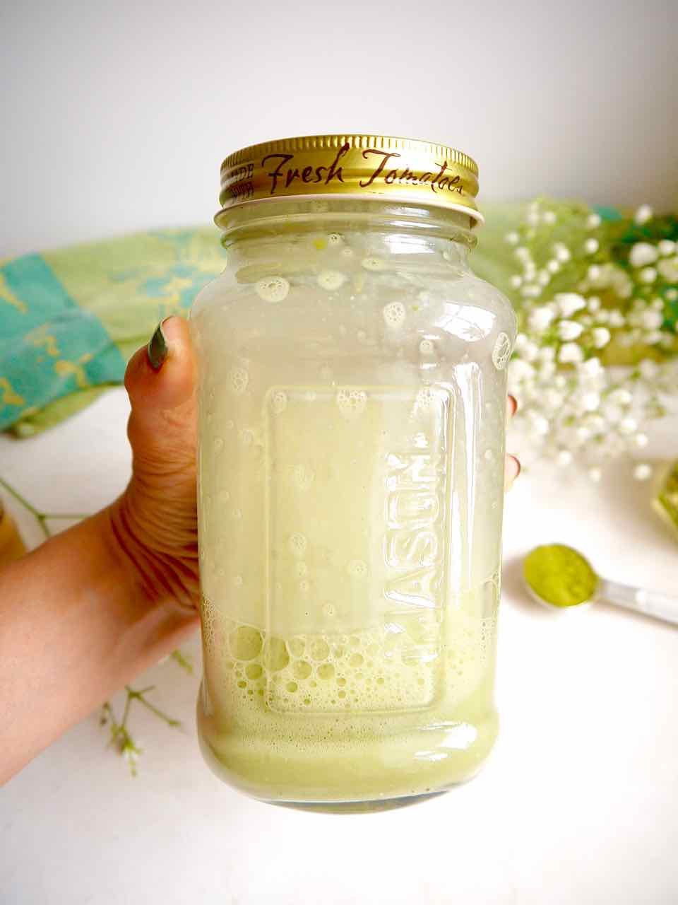 Mixed almond milk and matcha latte in a mason jar.