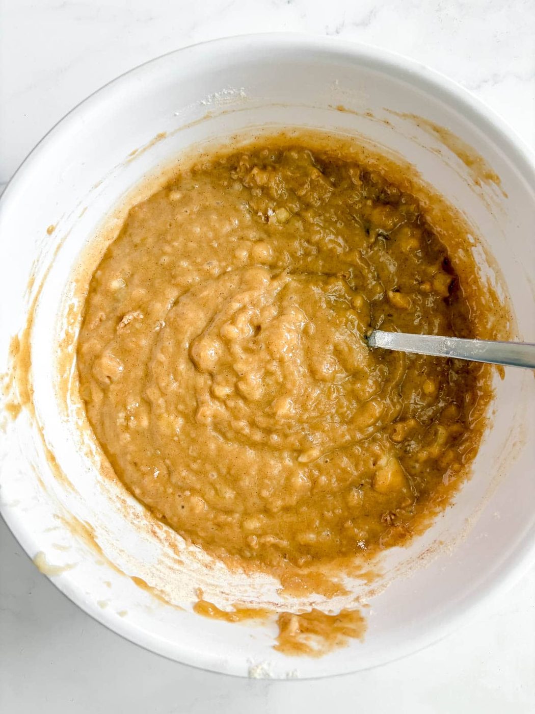 Olive oil banana bread batter in a bowl.
