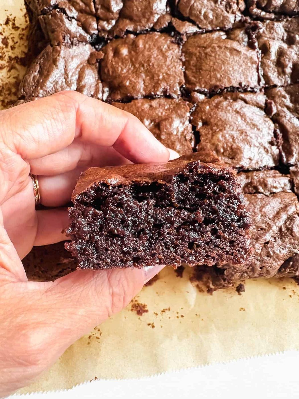 A slice of olive oil brownie in one's hands.