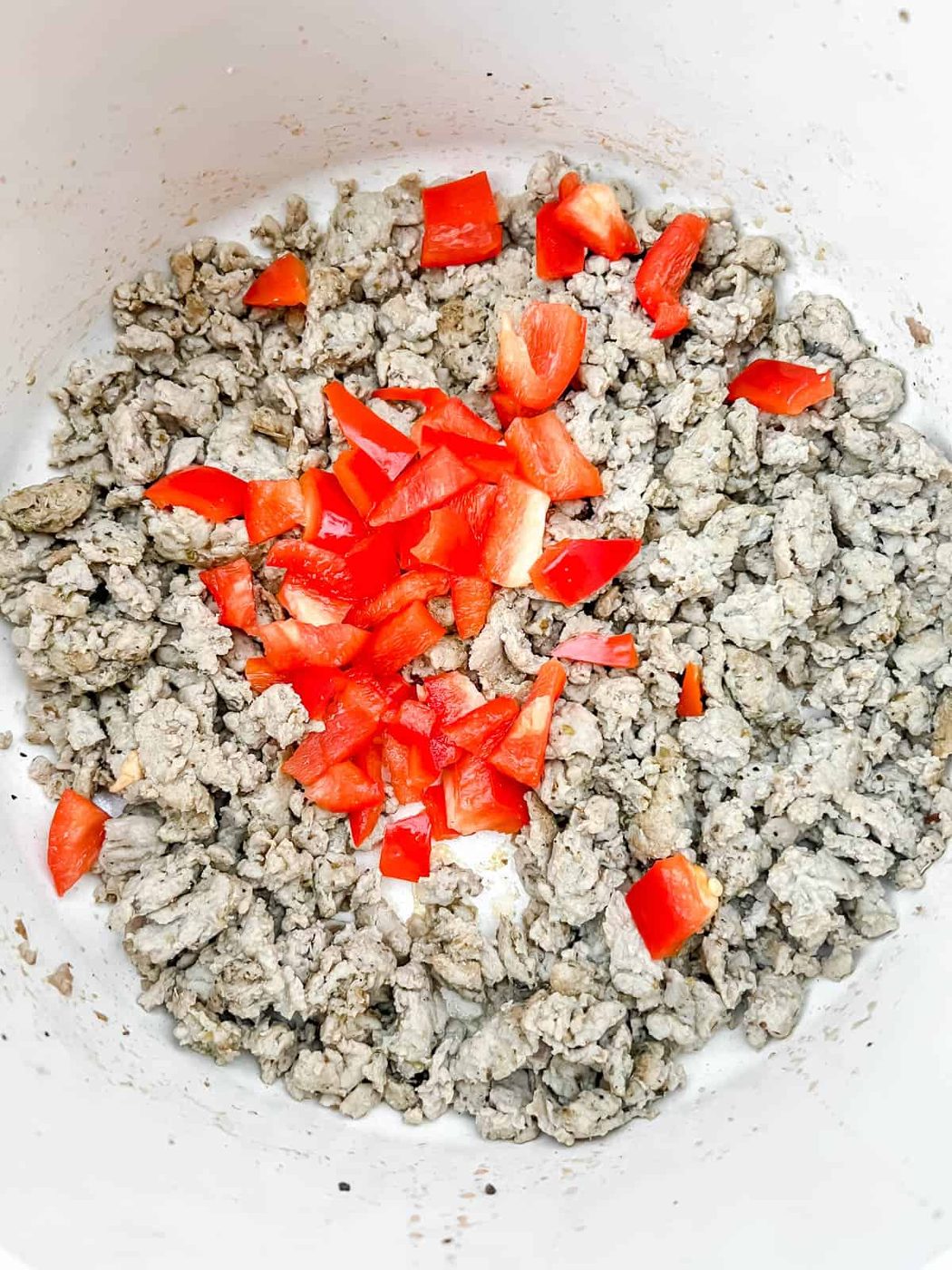 browned turkey in a pot with red peppers.
