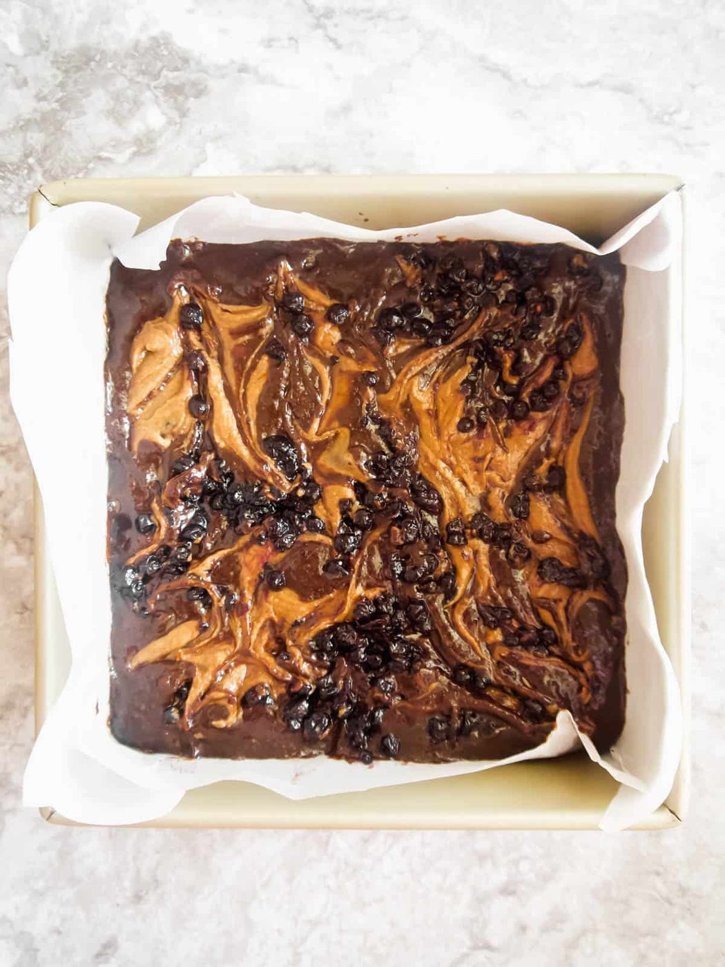 Swirls of almond butter and jelly on top of brownie before baking.