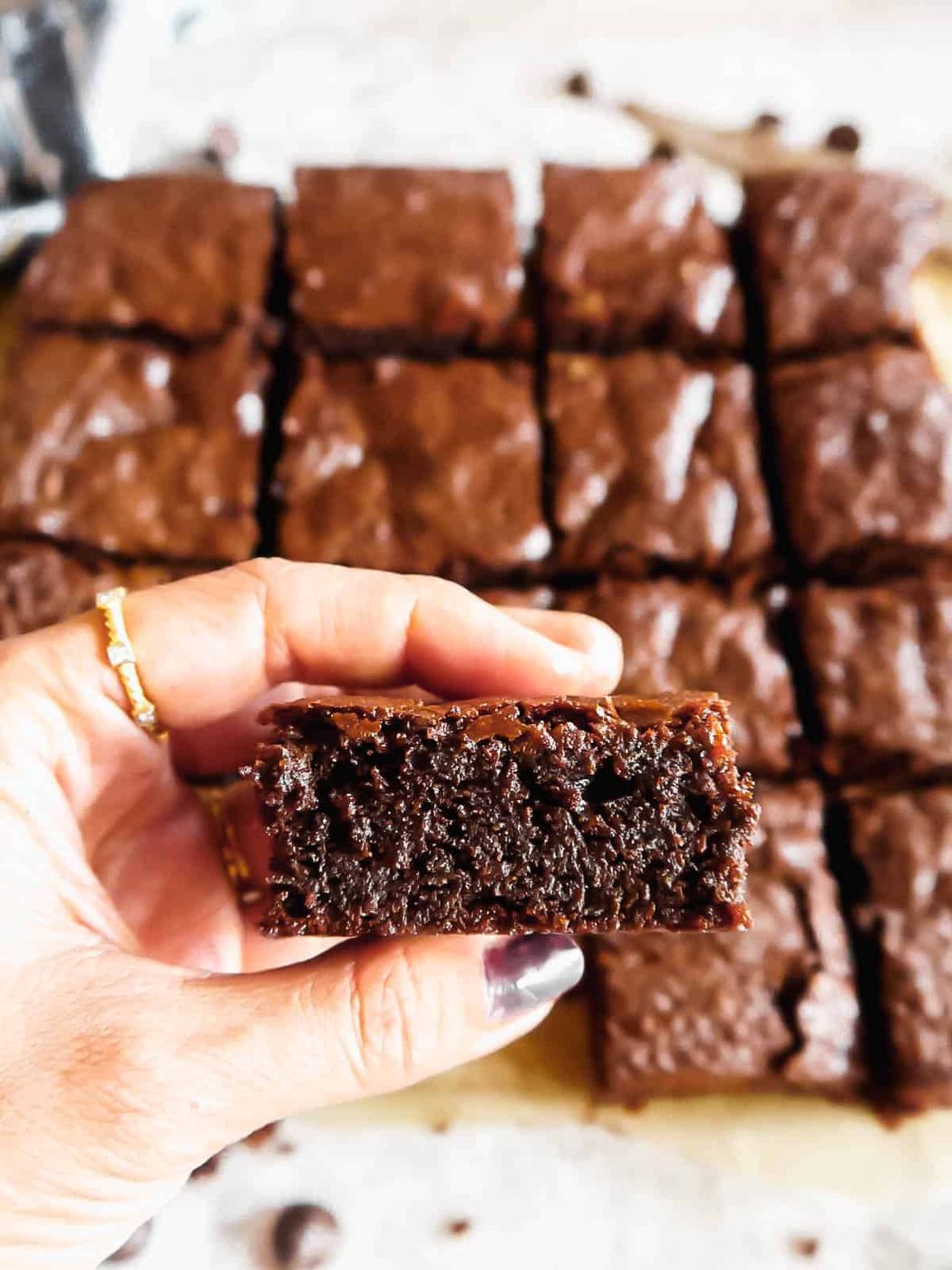 A slice of paleo brownie in hands.