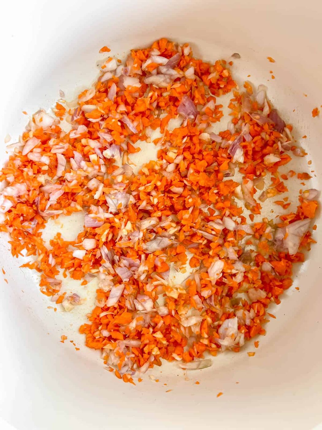 Minced carrot, onion, and garlic in a pan.