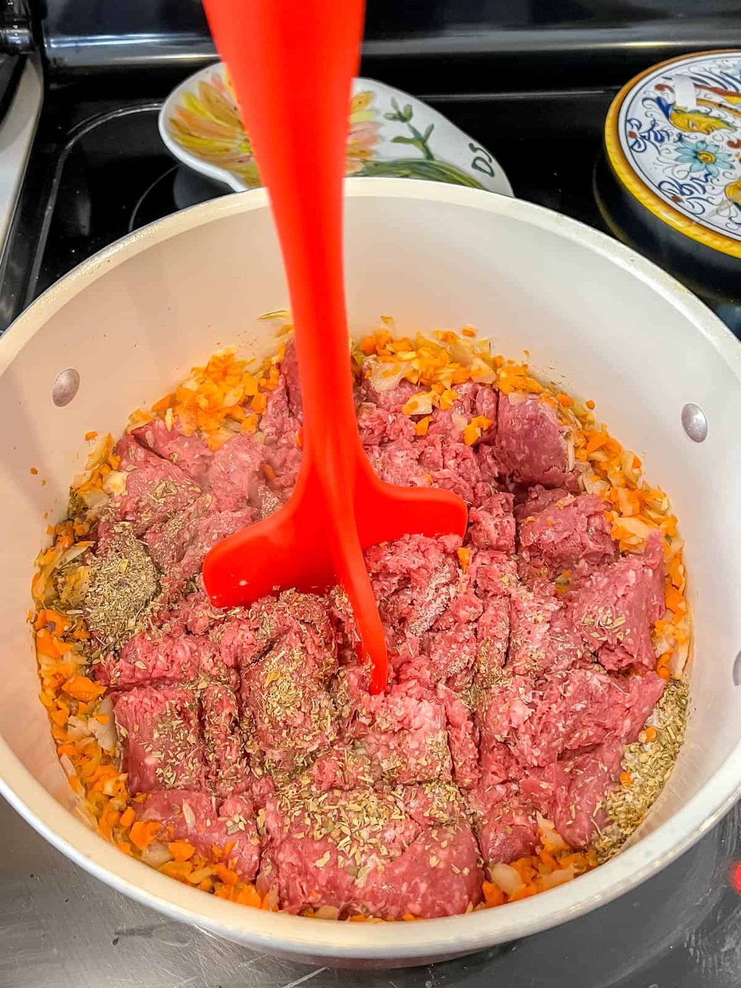 Using a meat masher to mash the meat.