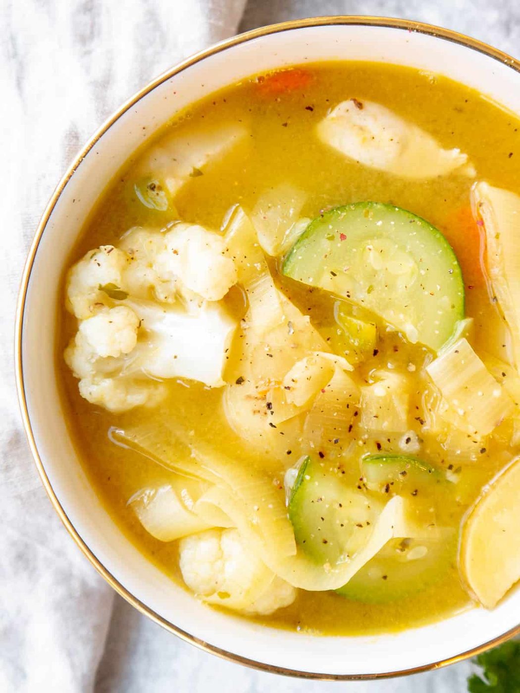 Chicken leek soup in a bowl with potatoes, carrots and zucchini.