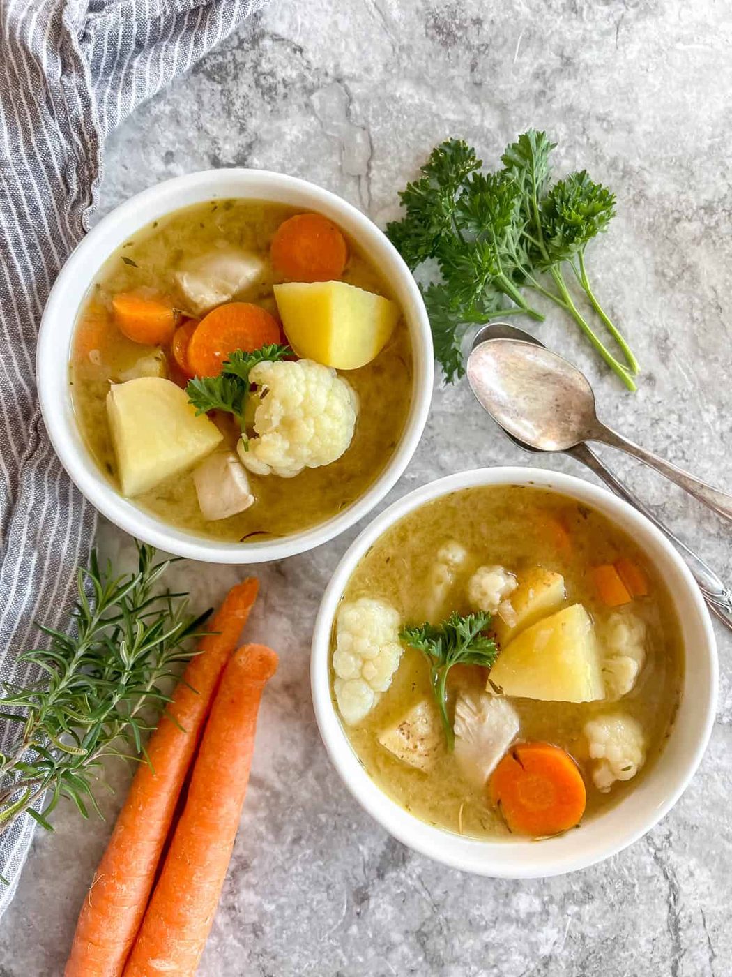 Lighter chicken soup made without noodles in two bowls.