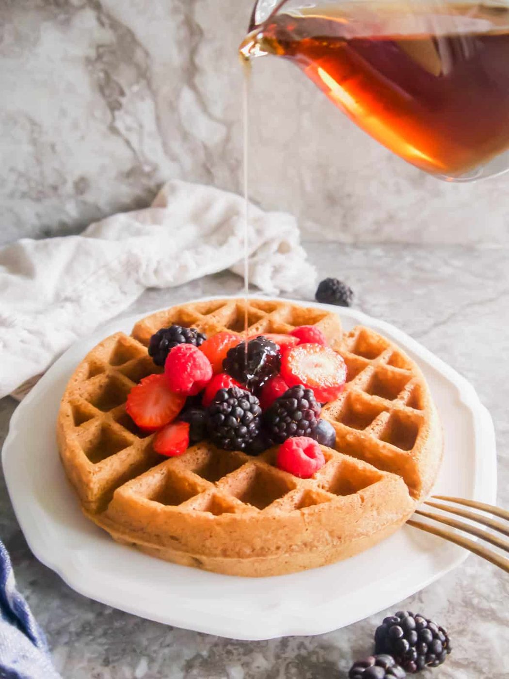 Maple syrup poured on top of dairy-free Belgian waffles.