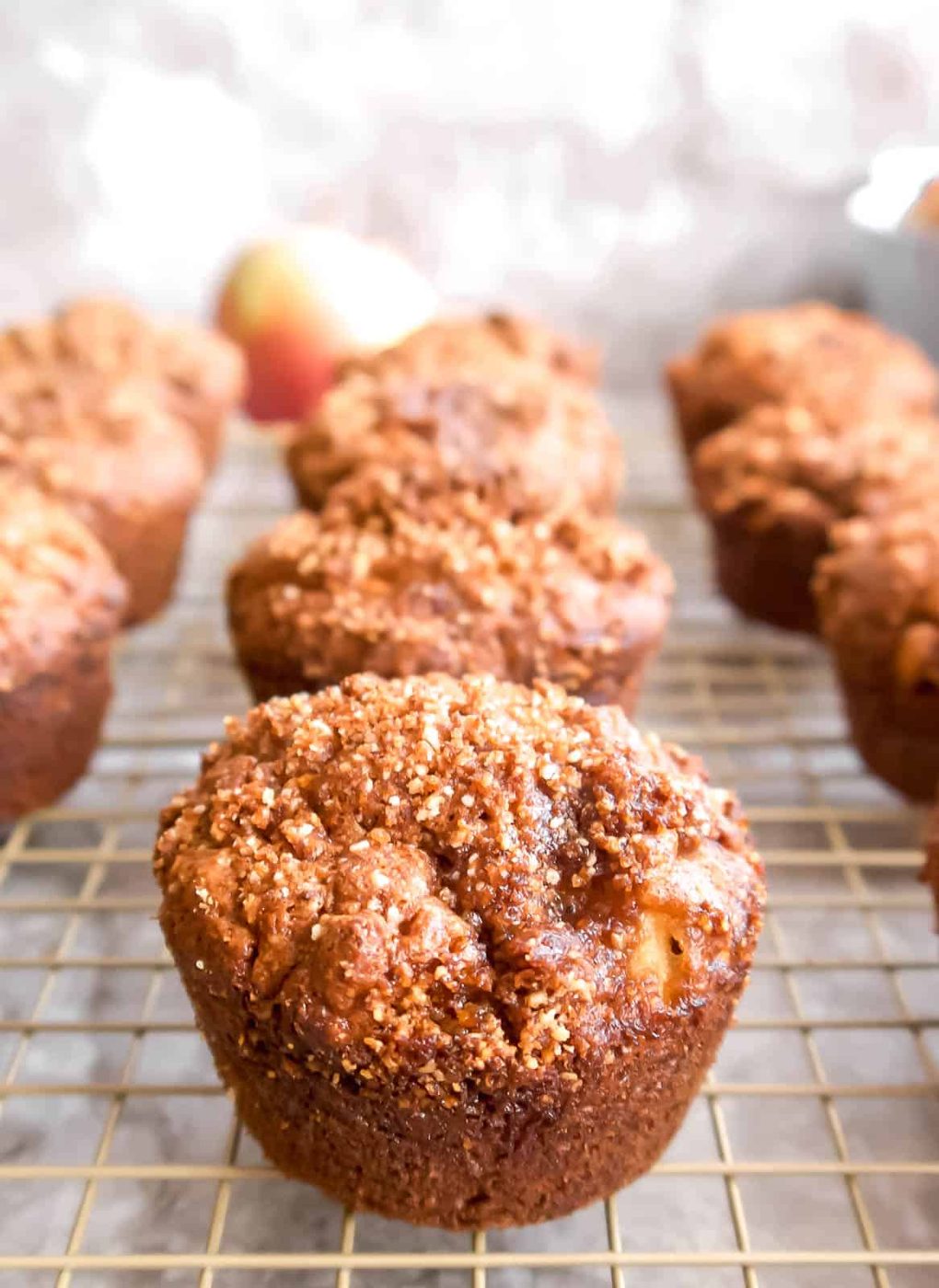 Lighter apple muffins on a rack cooling off.