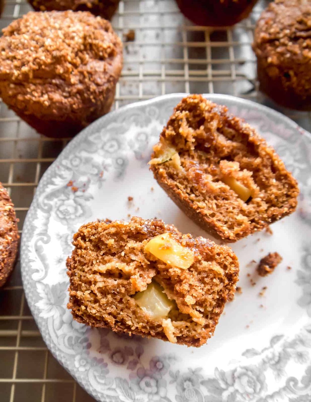 A Gluten-free apple muffin cut in half on a plate.