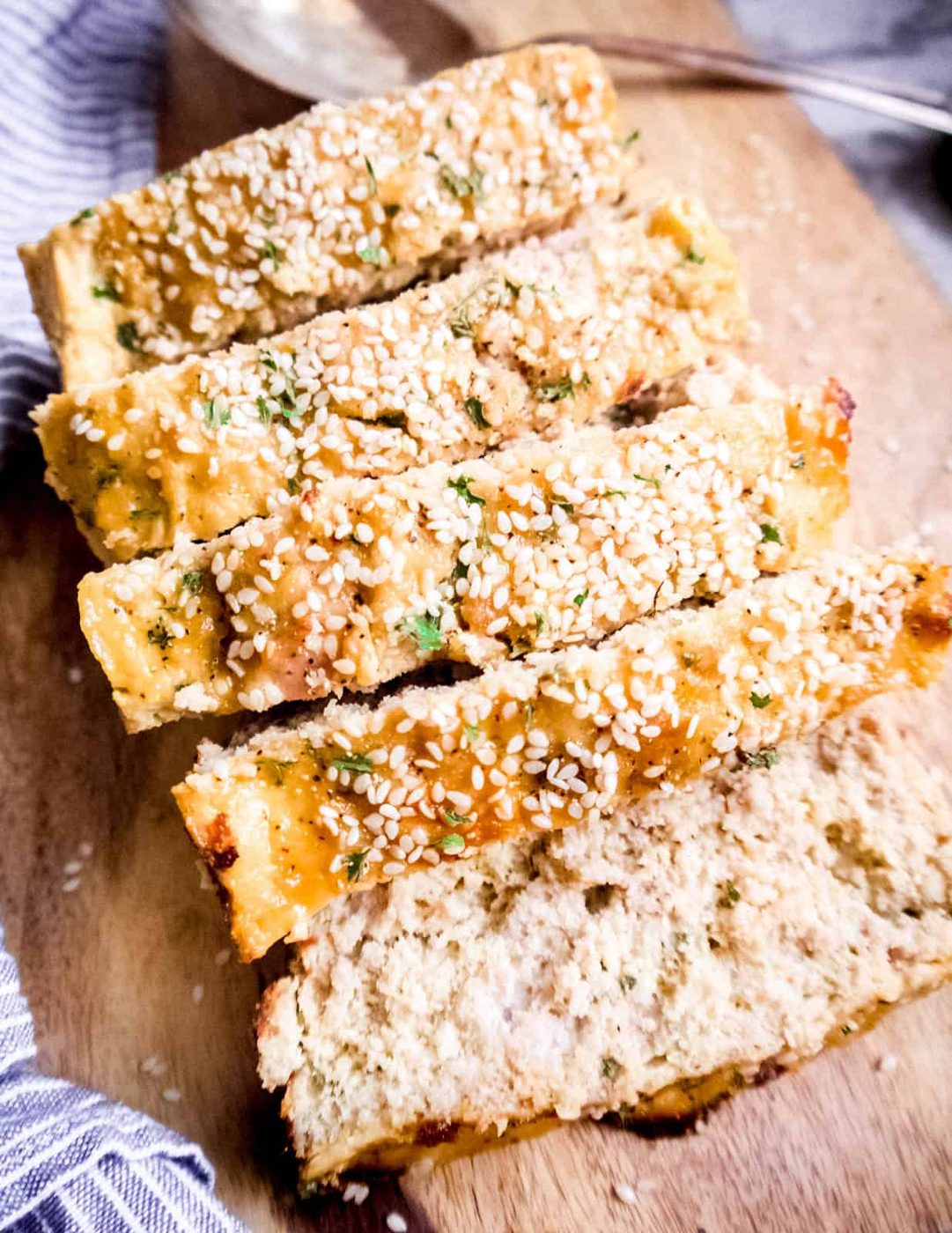 Sliced honey sesame paleo meatloaf on a cutting board.
