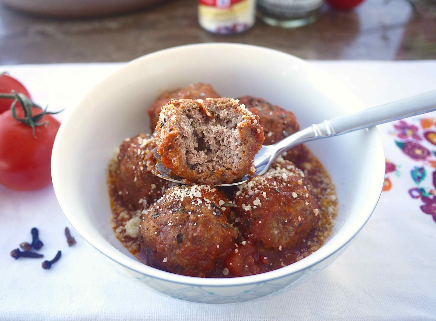 Gluten-free Italian meatballs in a bowl with a bite taken out of one of them.