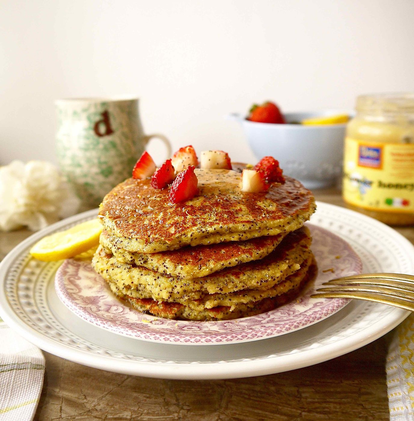 Gluten free lemon poppyseed pancakes stacked on top of each other.