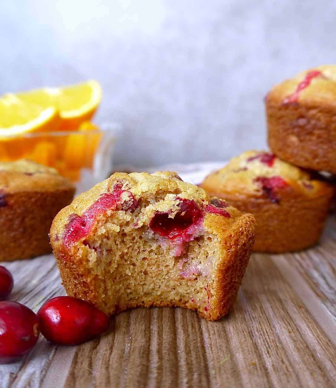 Bite taken out of an orange cranberry muffin.