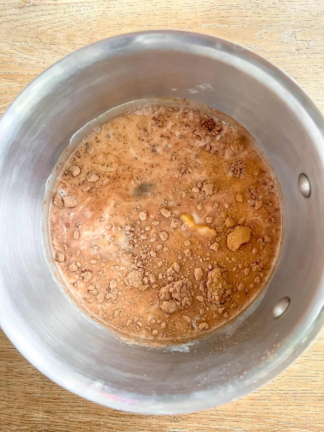All pumpkin hot chocolate ingredients in a sauce pan.