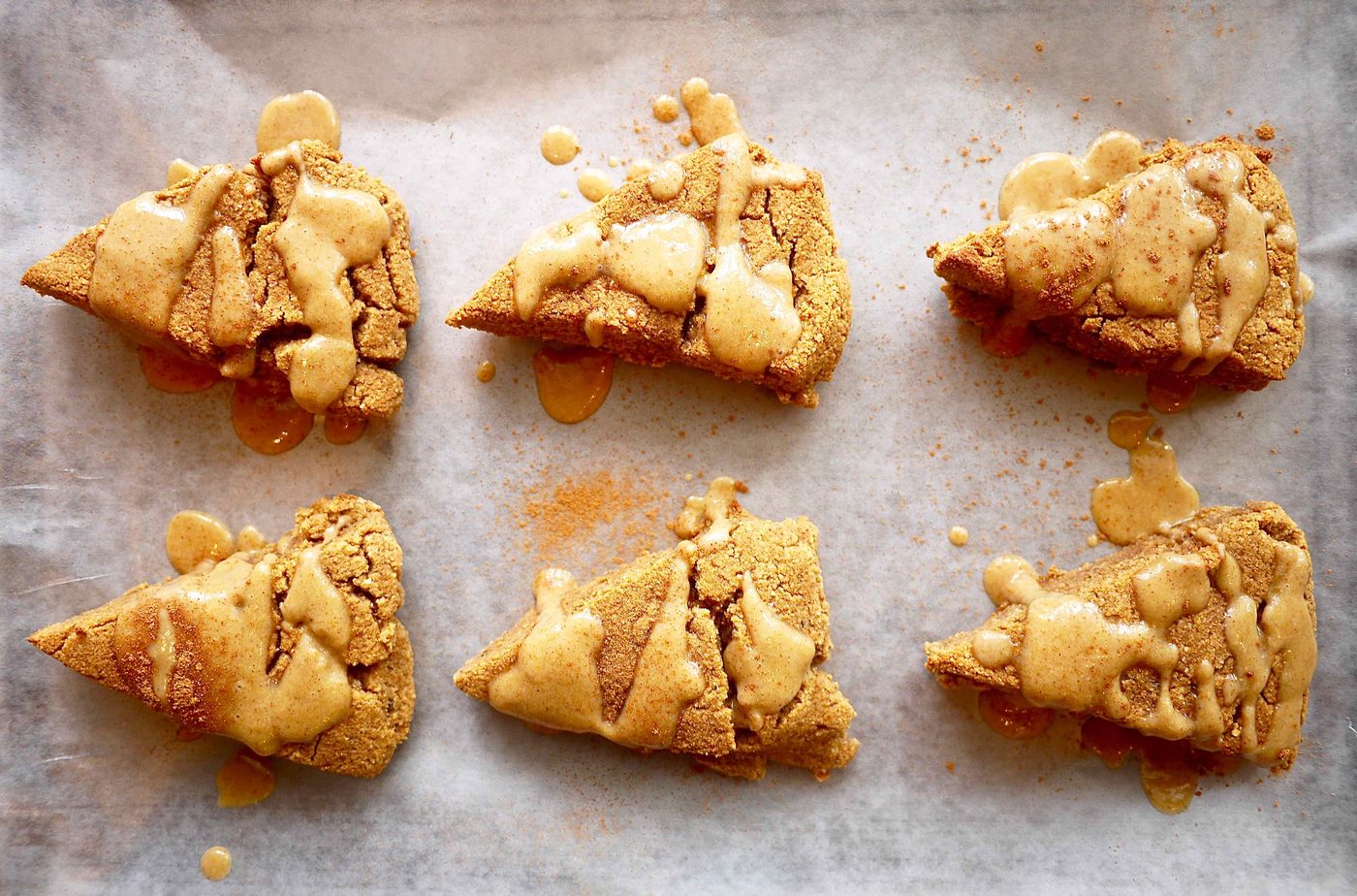 Lighter pumpkin scones on a cookie sheet.