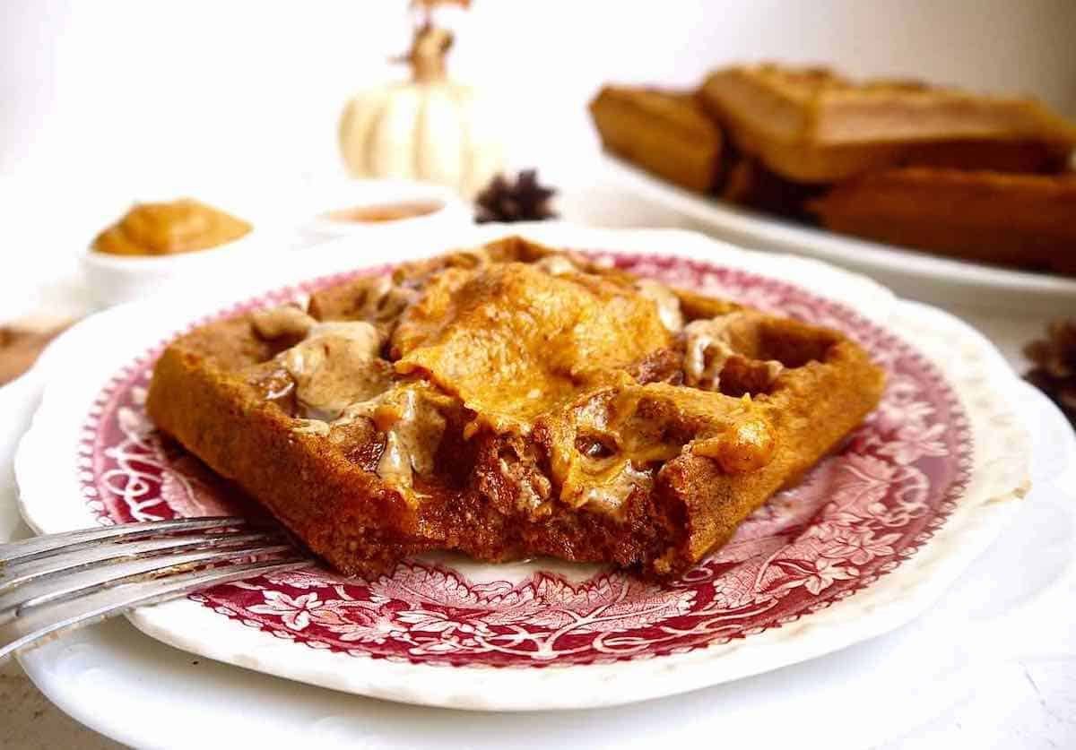 Paleo pumpkin waffles with a bite taken out of them.
