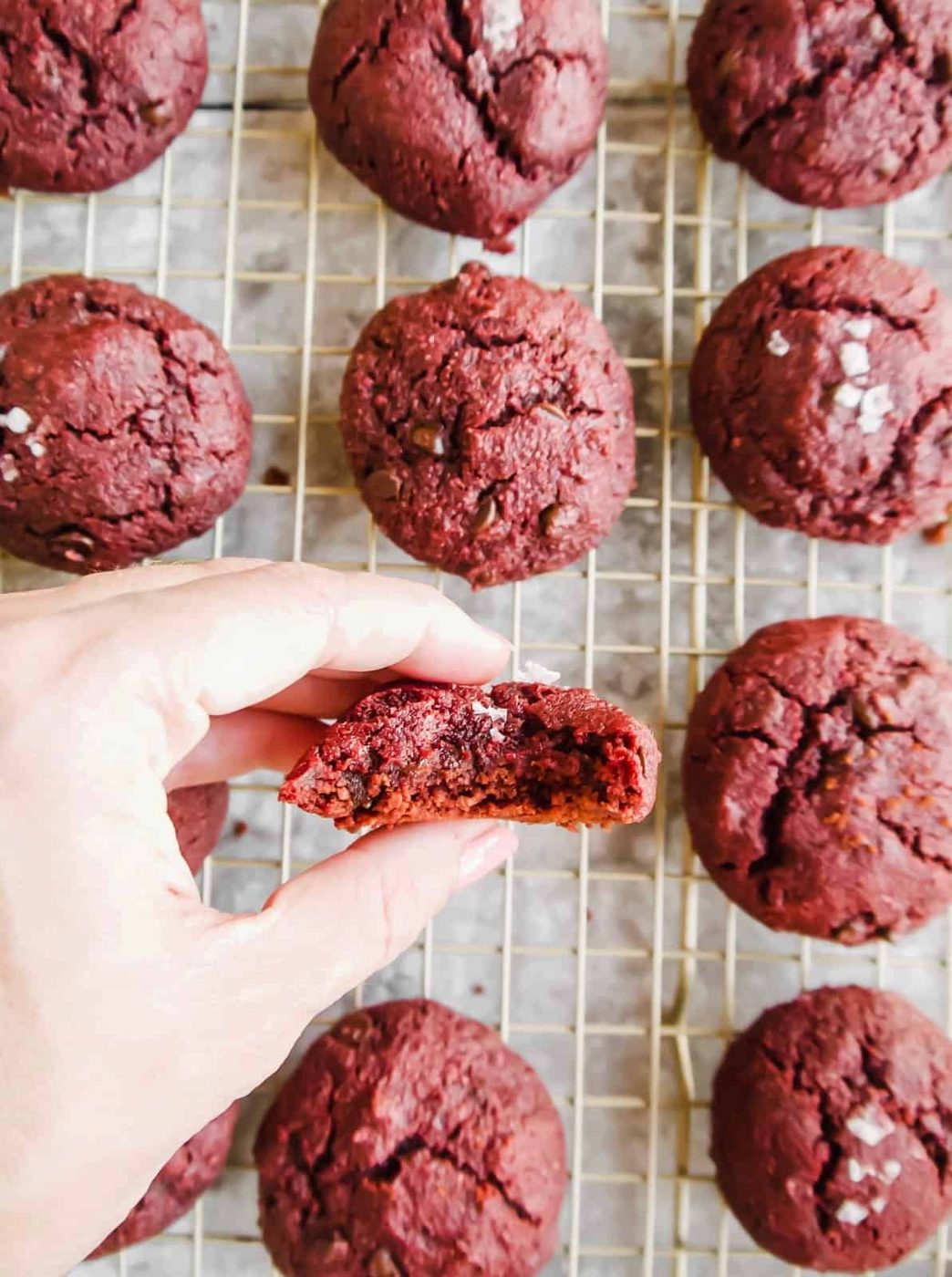 A bite taken out of a gluten-free red velvet cookie.