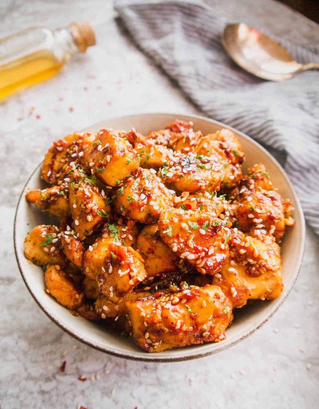 Lighter honey sesame chicken breast in a bowl with sesame seeds on top.