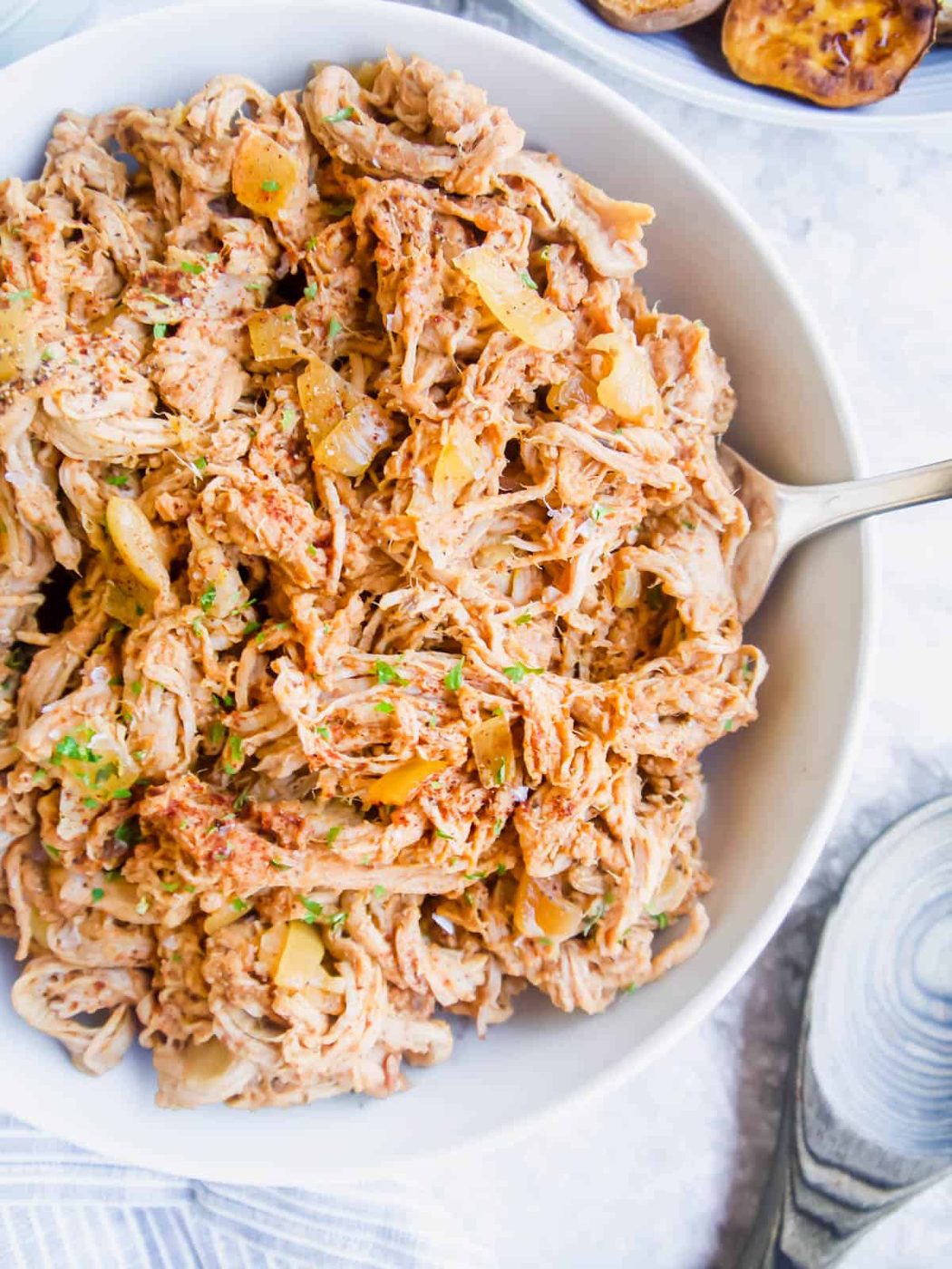 Paleo pulled pork in a bowl with a spoon.
