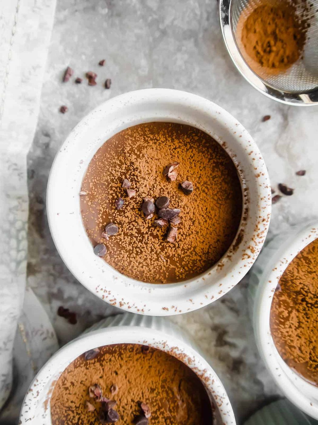 Dairy-free chocolate pudding in ramekins with chocolate chips on top.