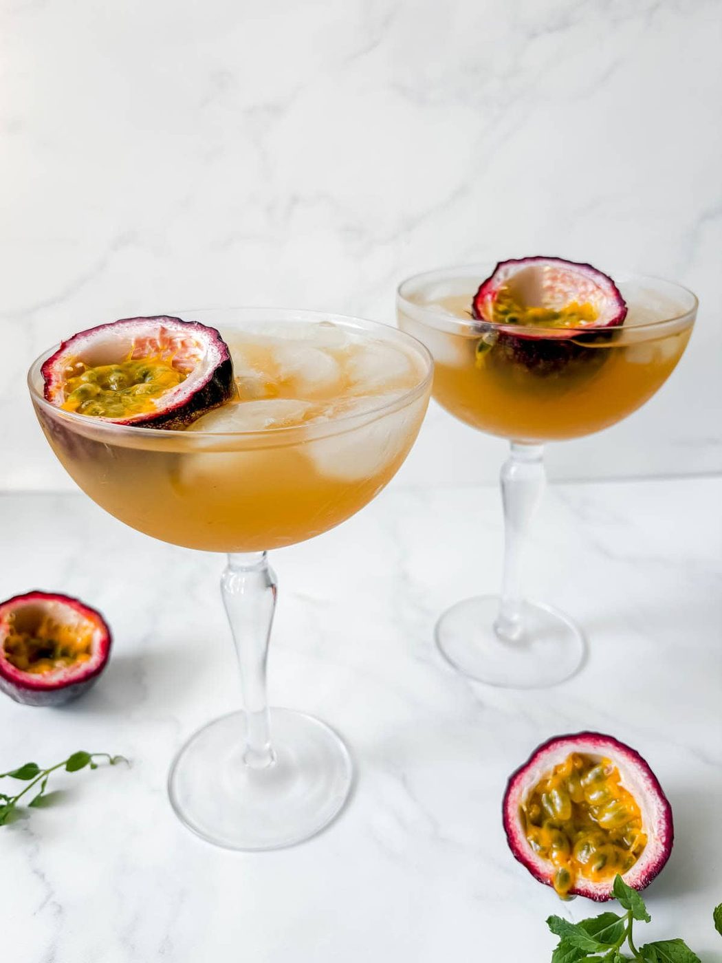 Passion fruit gin cocktails garnished with passion fruit.