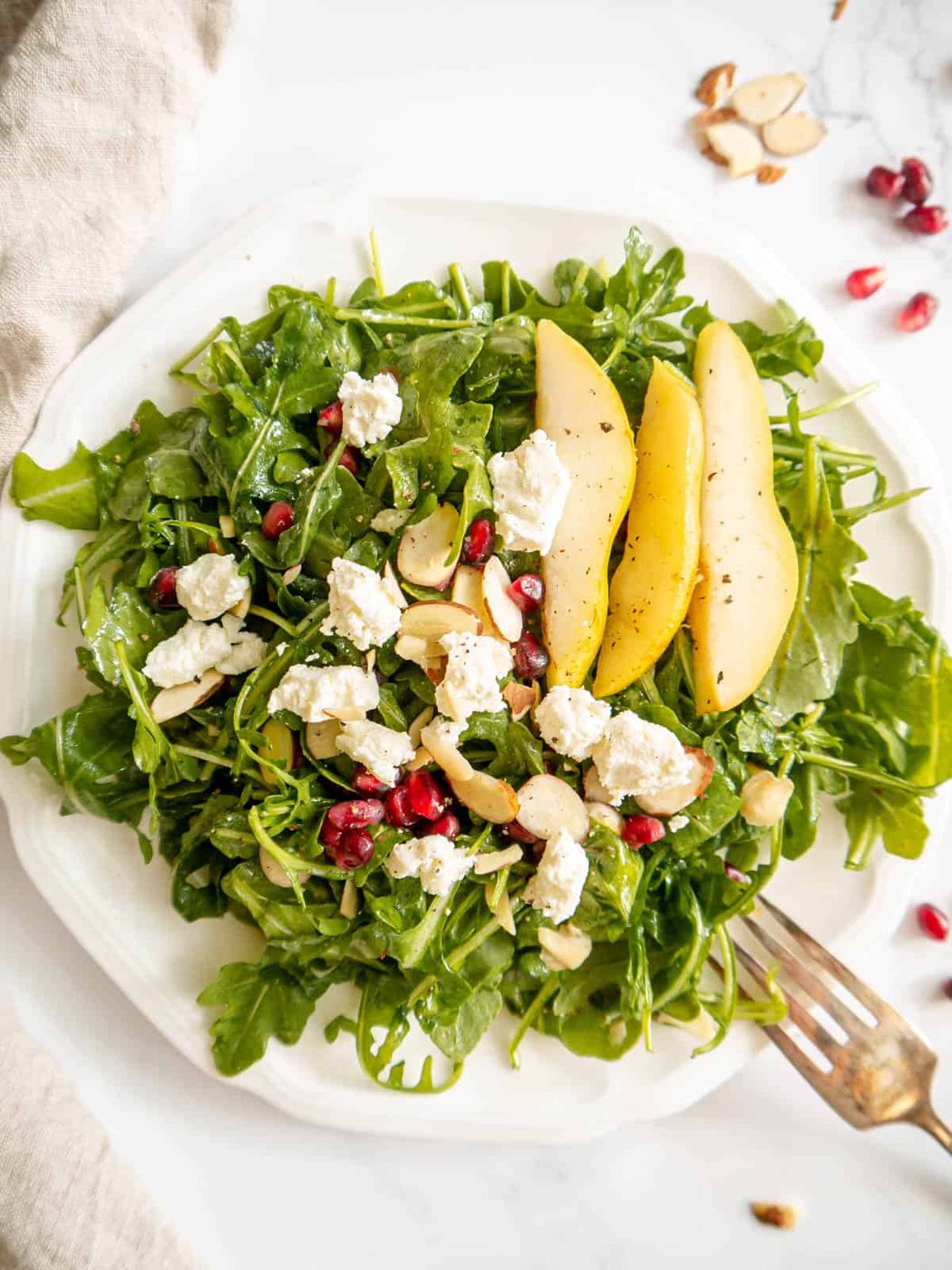Arugula pear goat cheese salad on a plate.