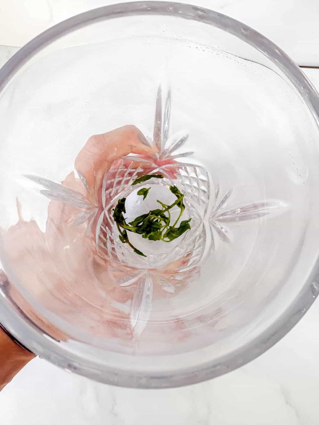 Muddling the mint leaves in a drink shaker.