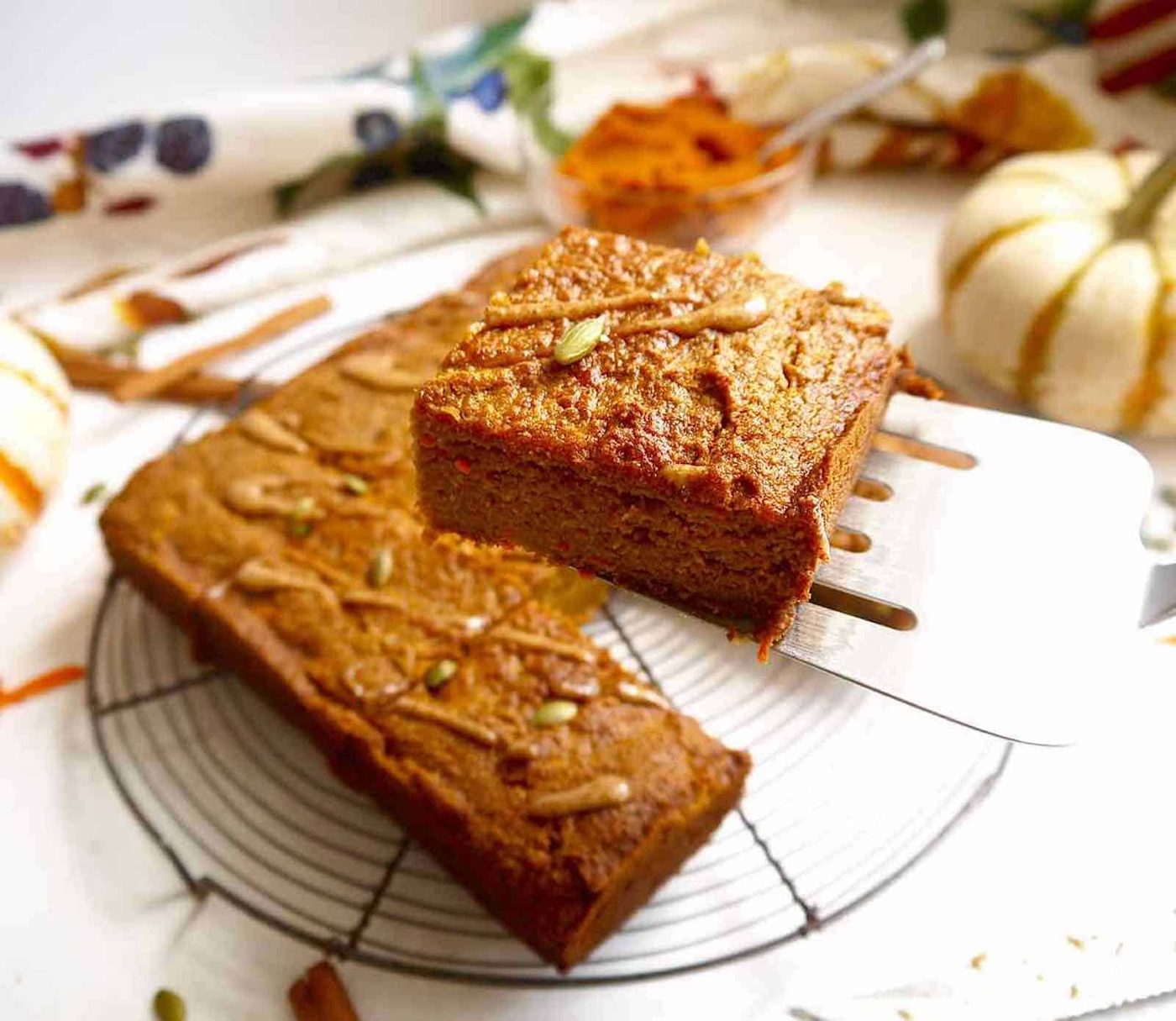 A slice of pumpkin carrot cake being lifted out of the plate.