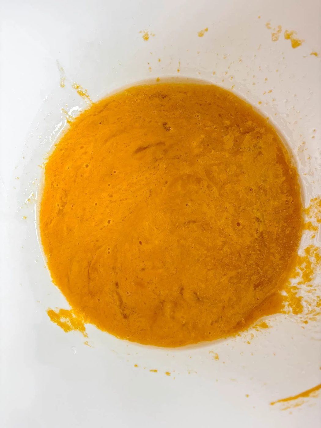 Wet ingredients in a bowl for lighter pumpkin muffin recipe.