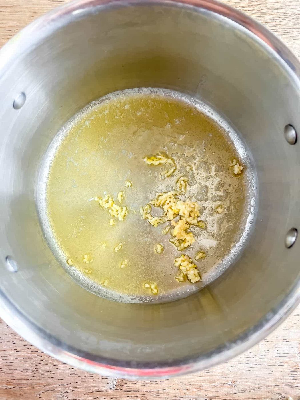 Garlic added to melted butter in a pan.