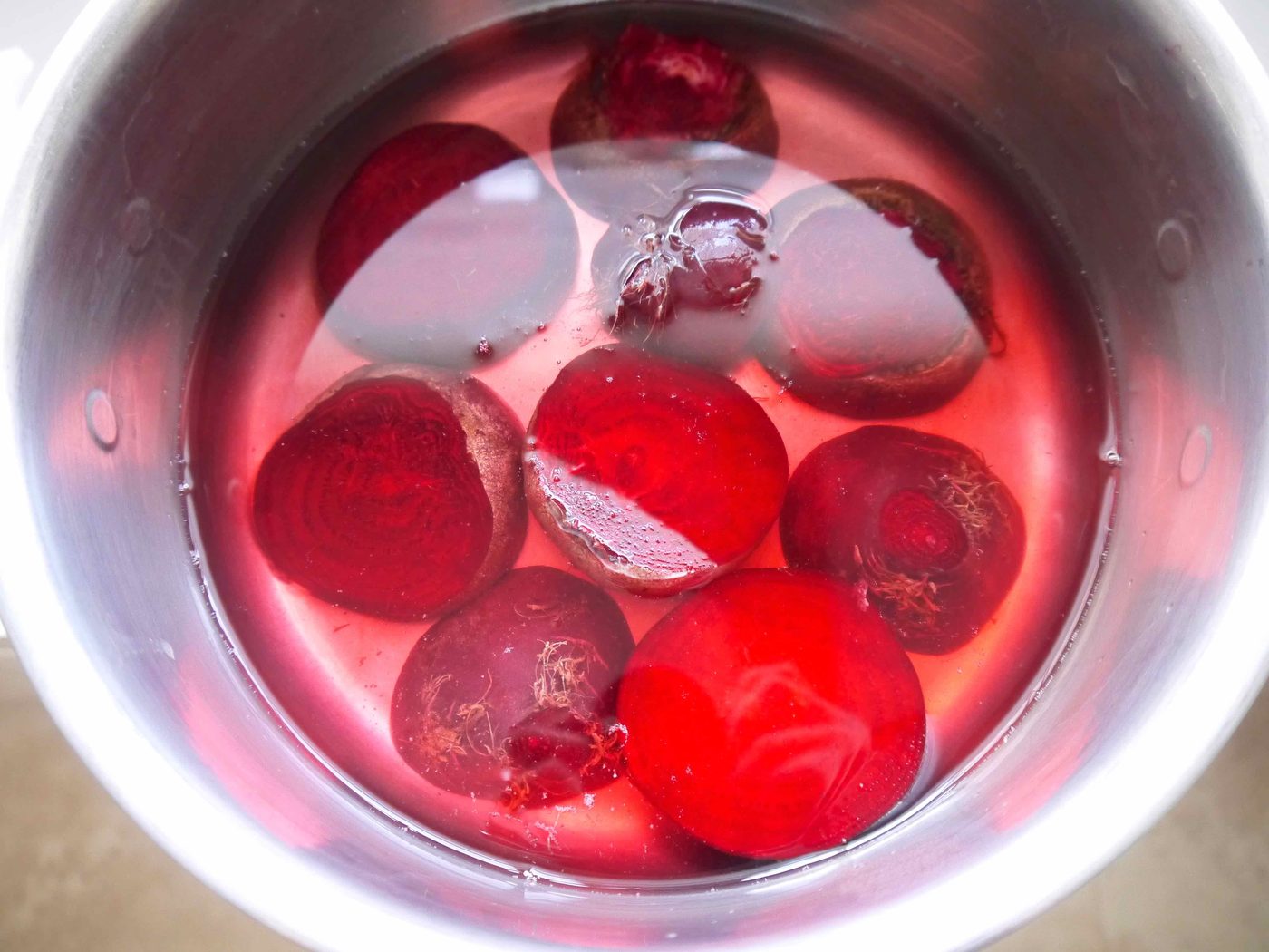 Beets in a pan covered in water.