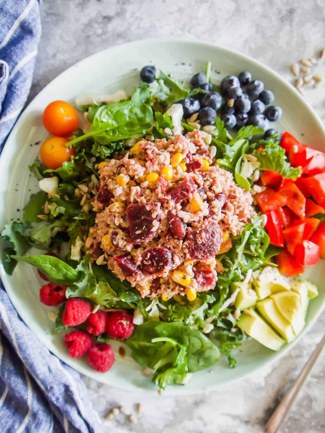 Quinoa Beet Salad in a plate with veggies and fruit.