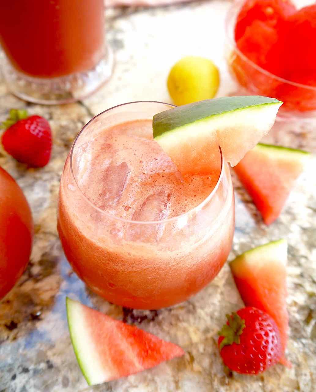 Watermelon cucumber juice in a cup with strawberries.