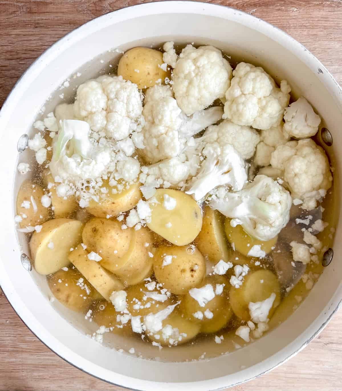 Potatoes and cauliflower in boiling hot water.