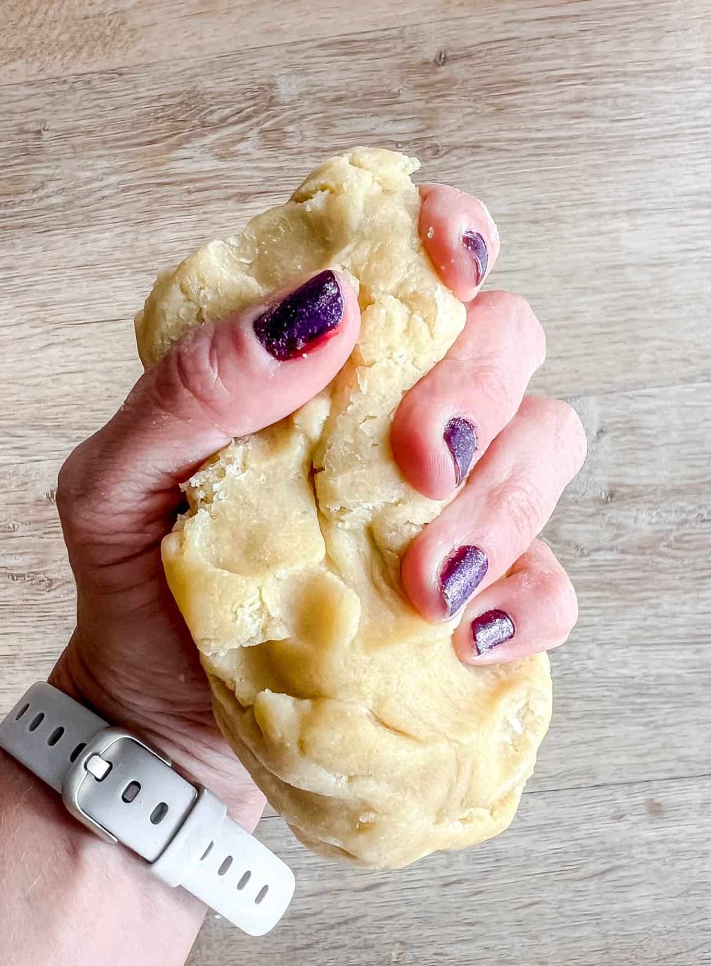 Mushing the sable cookie dough in ones hands.