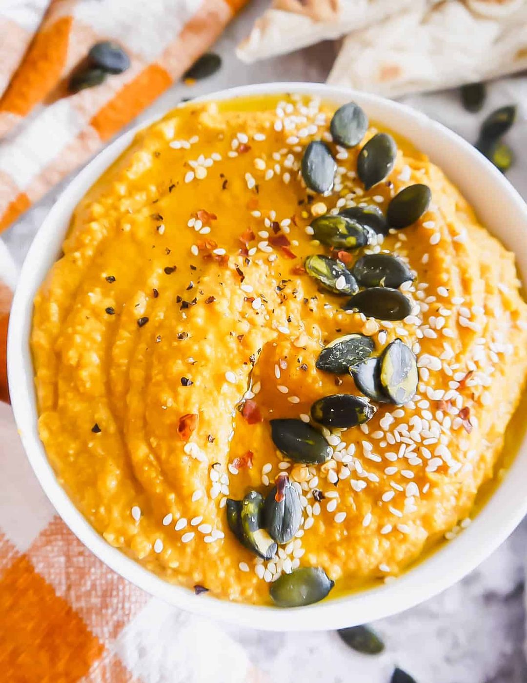 Creamy pumpkin hummus in a bowl.