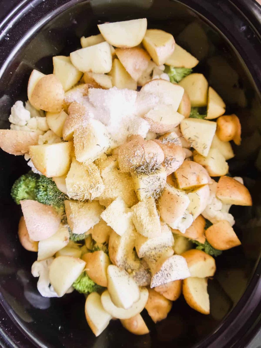 Potatoes with coconut cream and herbs added to the slow cooker.