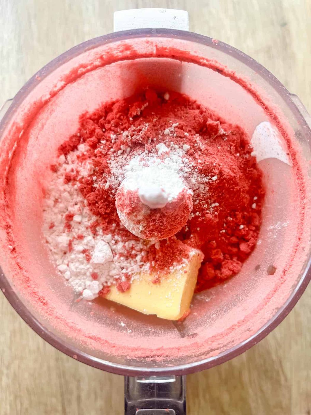 Strawberry frosting ingredients in a food processor.