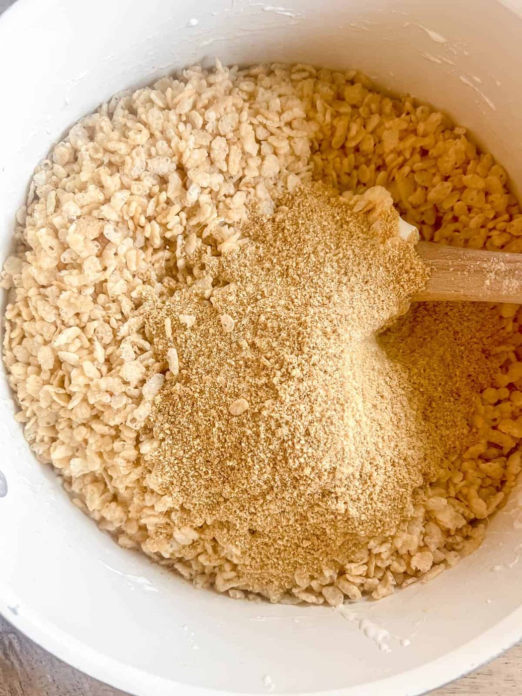 Rice krispie cereal and graham crackers added to melted marshmallows.