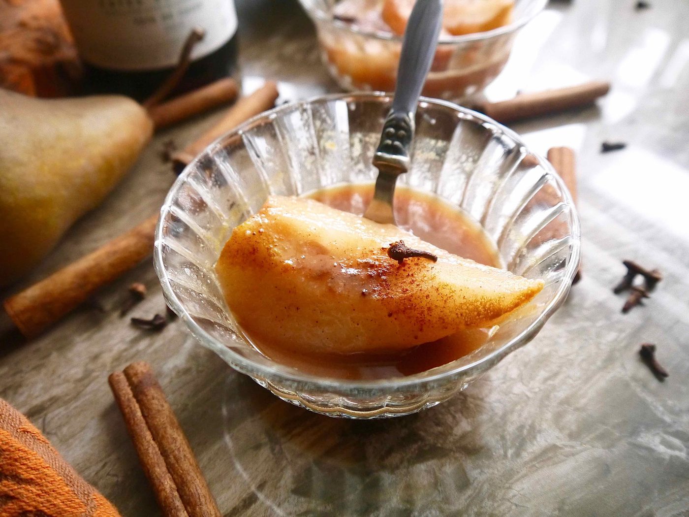 Poached pears in orange juice and wine in a bowl.