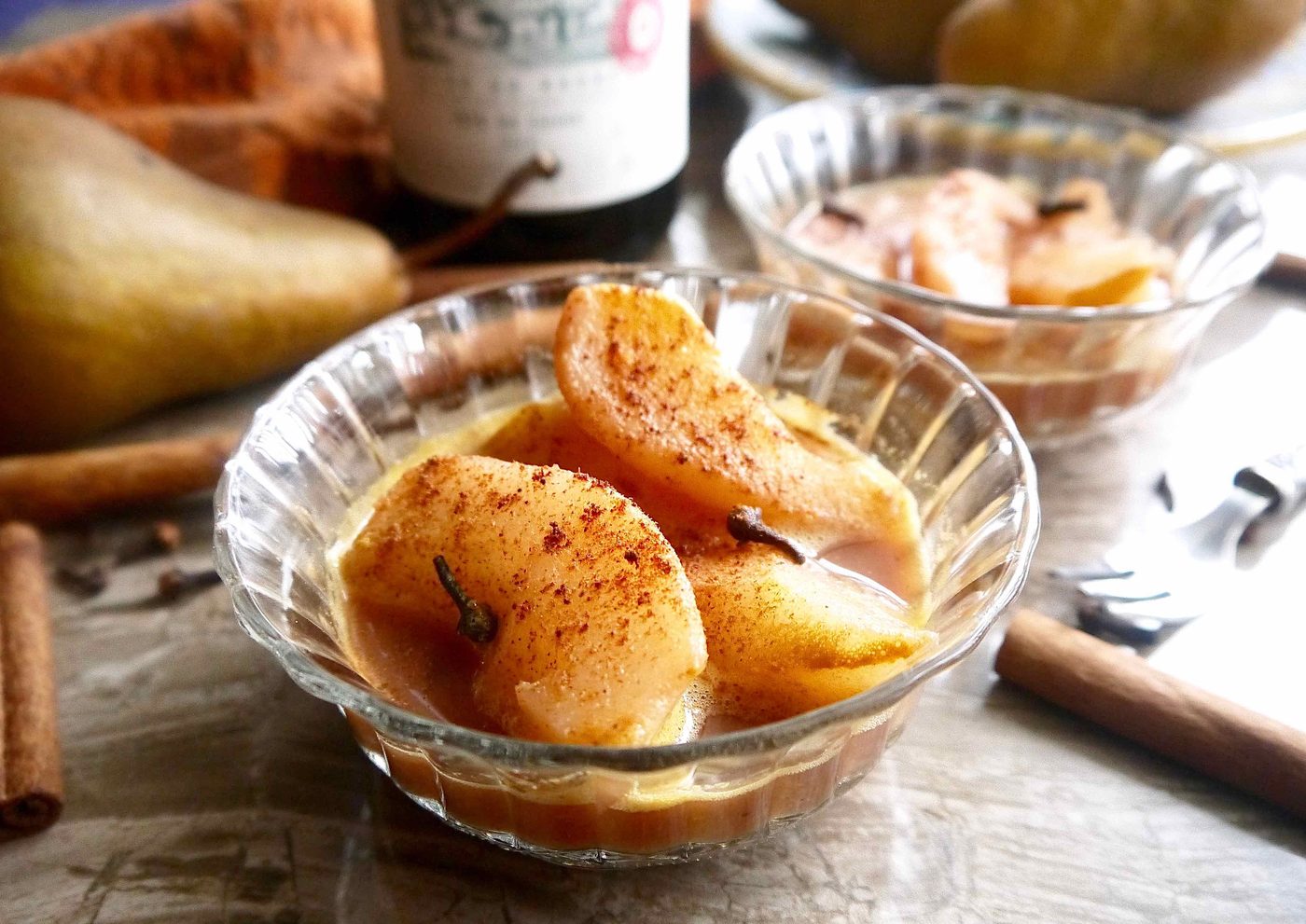 Cinnamon poached pears in two bowls.