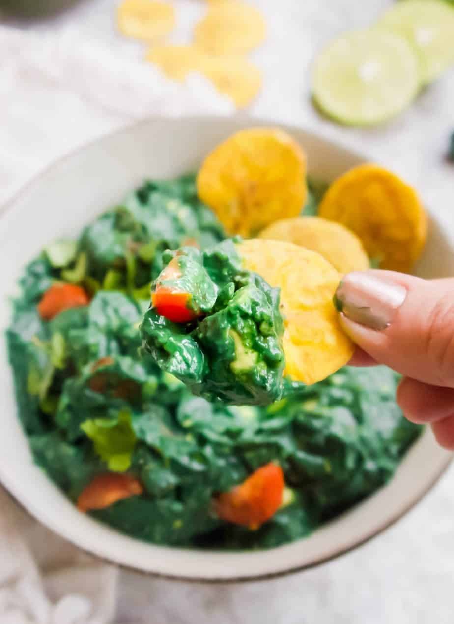 A chip dunking into Spirulina Guacamole.