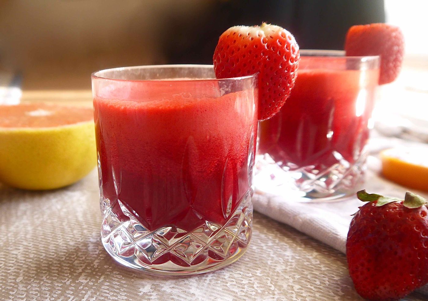 Side angle of strawberry and beet juice in a glass.
