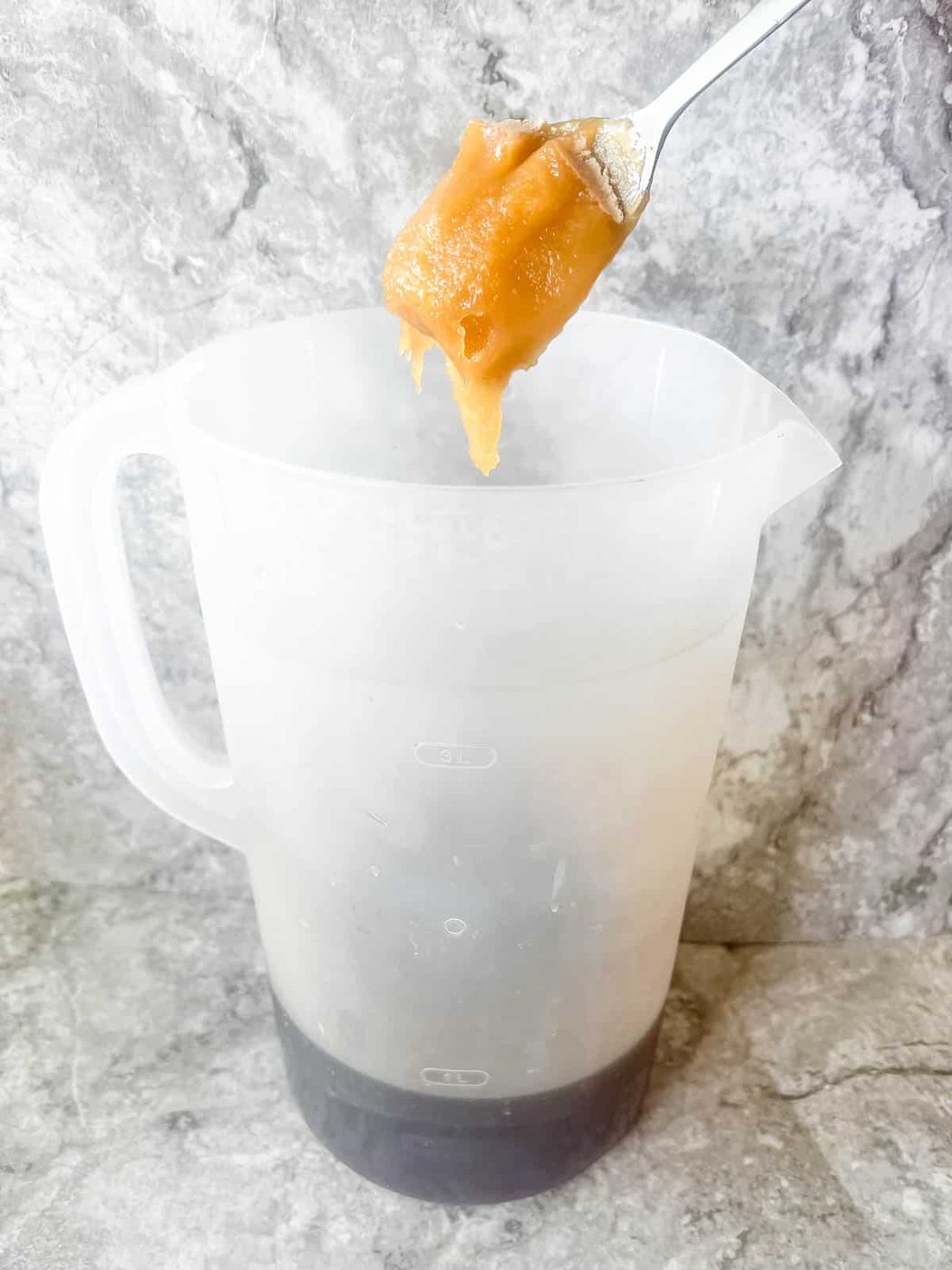 Adding honey to strawberry iced tea.