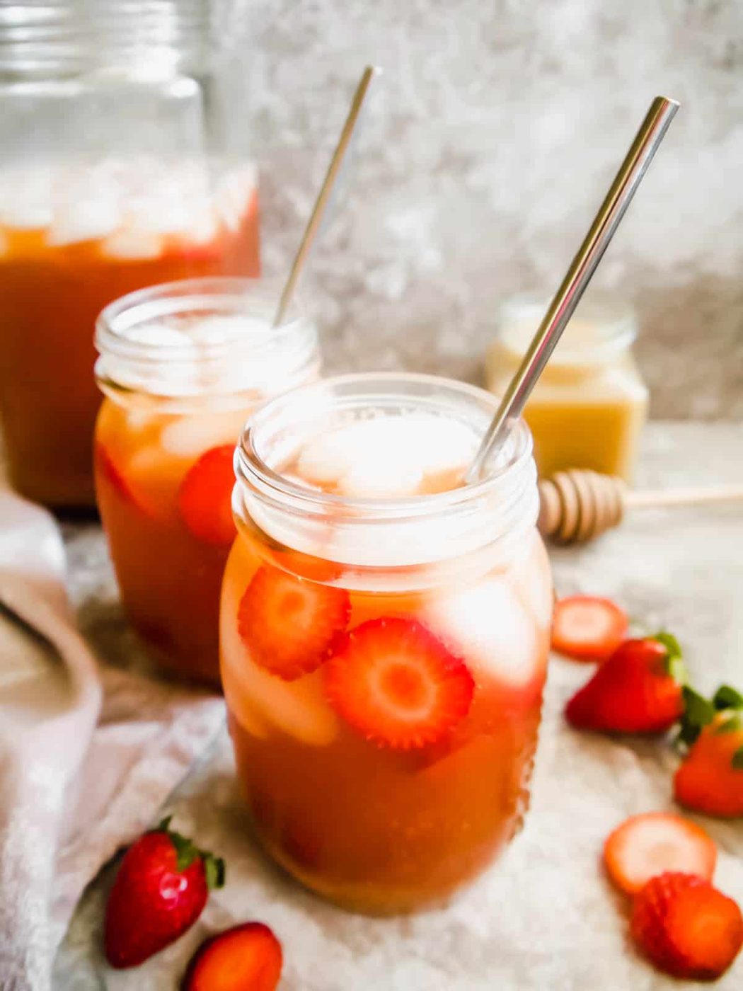 Strawberry Sweet Iced Tea in mason jars with strawberries in them.