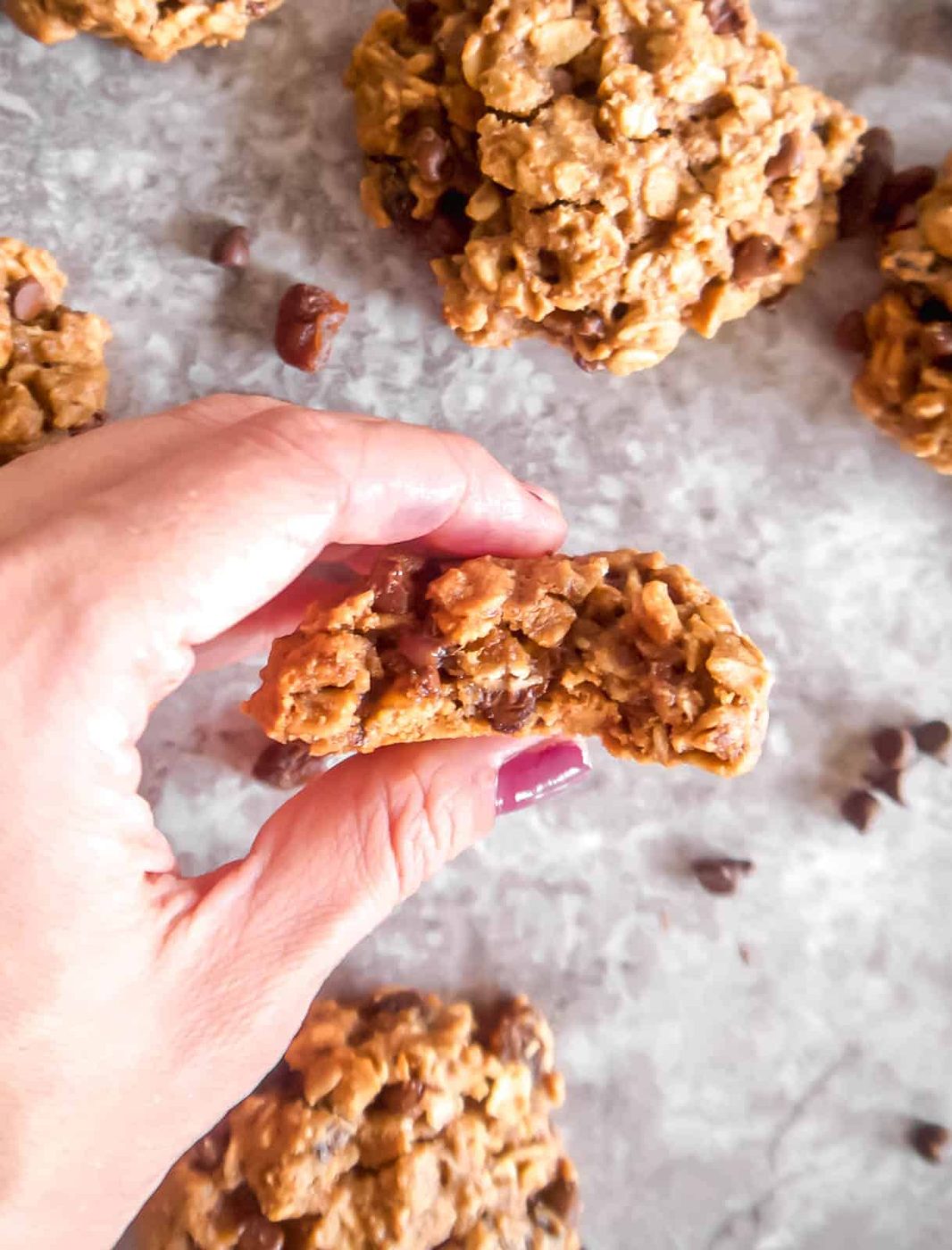 A bite taken out of a dairy free lactation cookie held in a hand.