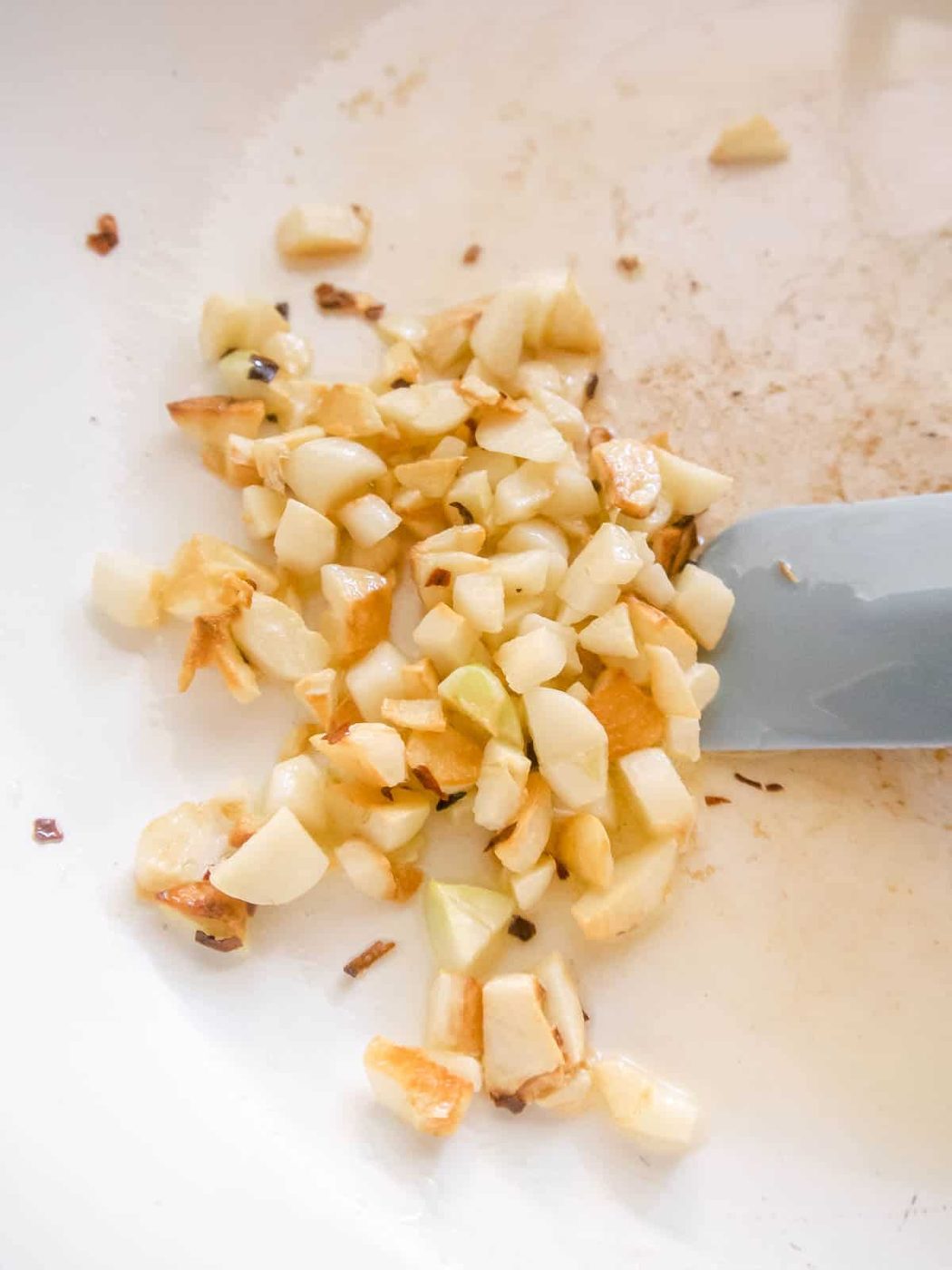Chopped garlic in a pan sautéing.