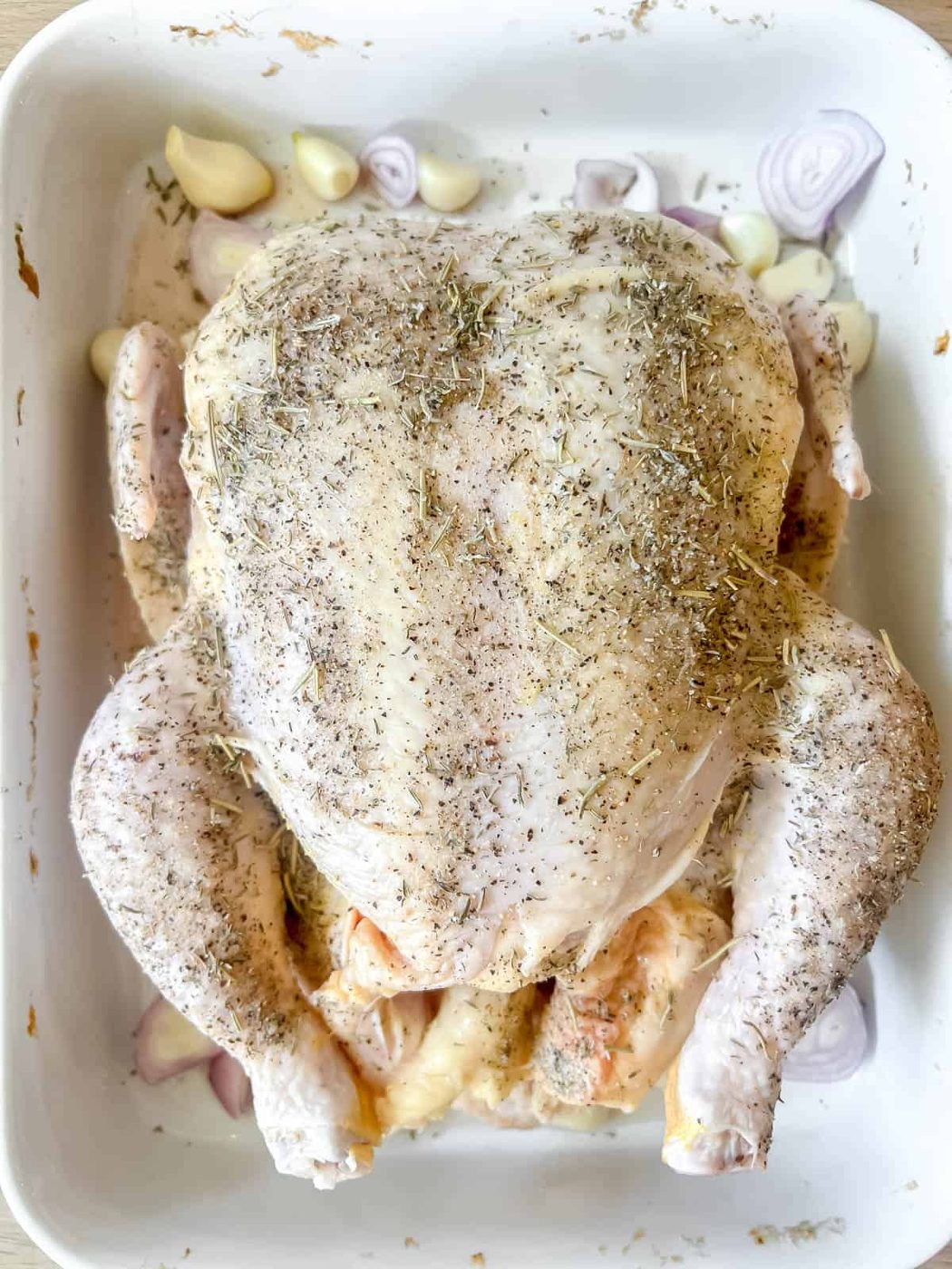 Garlic and onion in pan with raw chicken.